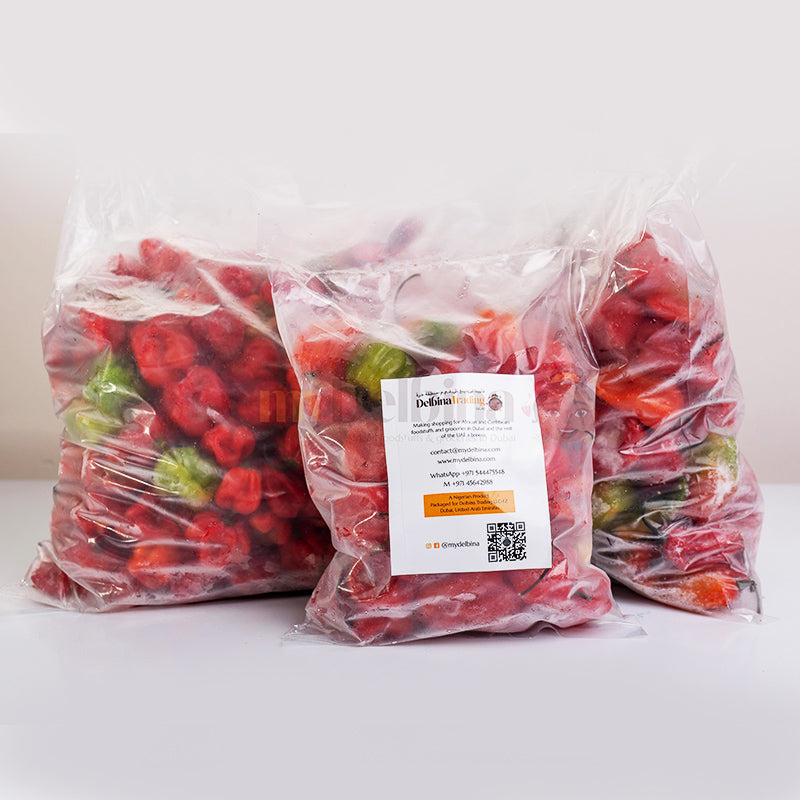 Two plastic bags filled with fresh red Scotch Bonnet peppers, with a label showing the product details.